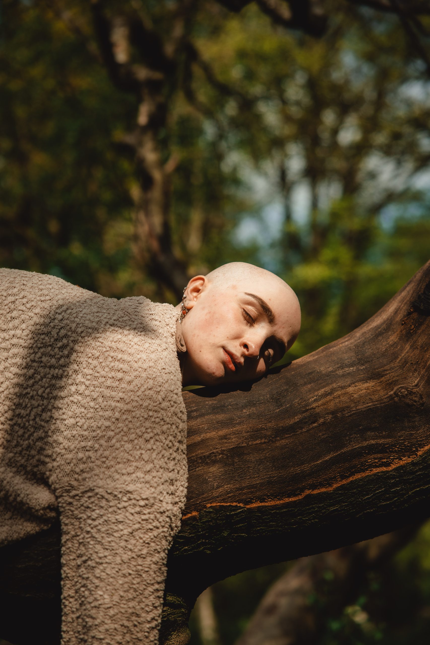 bald woman sleeping on tree