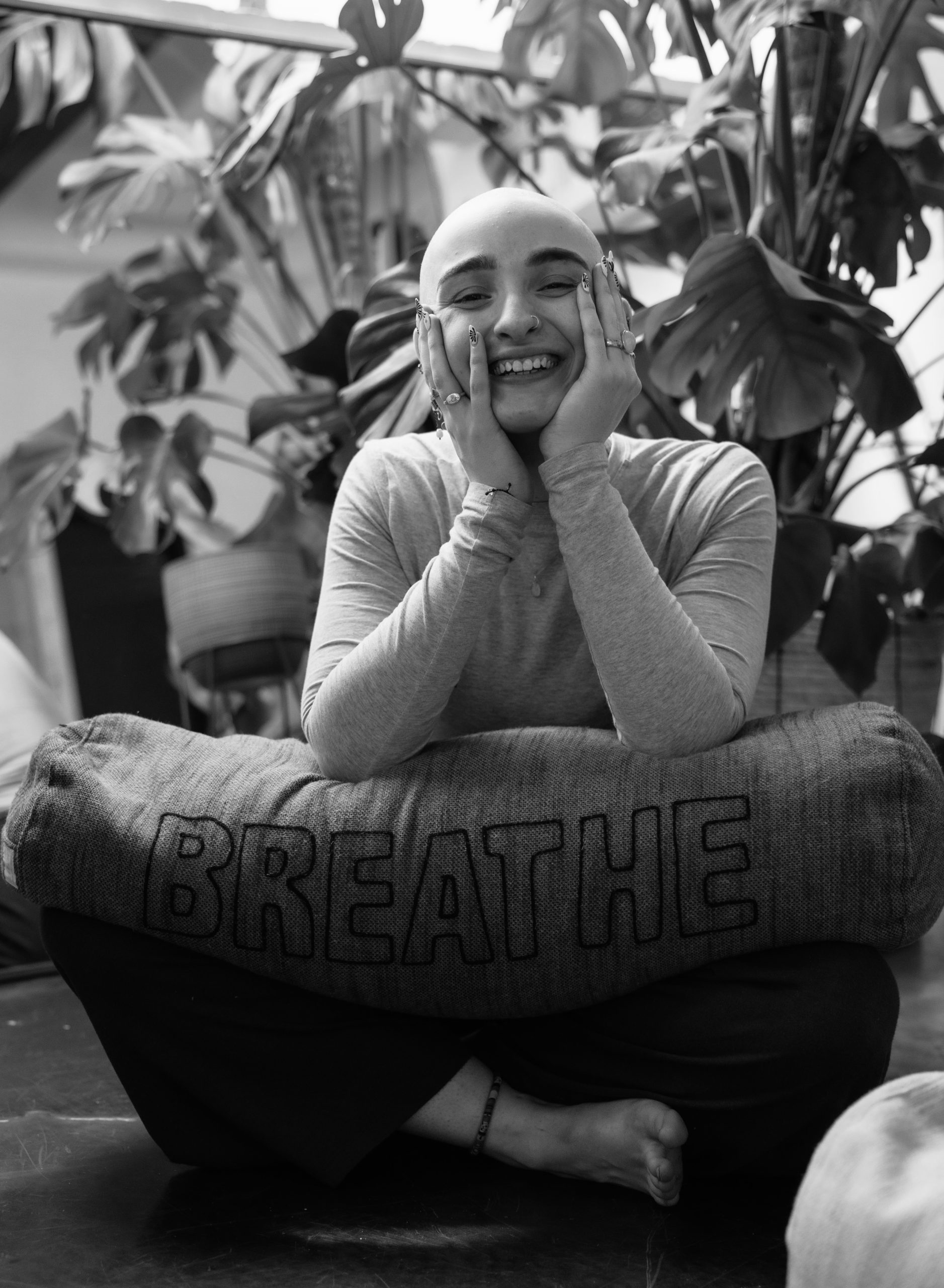 Person practicing slow, intentional movement in a bright studio space — somatic yoga for nervous system regulation and embodied awareness.