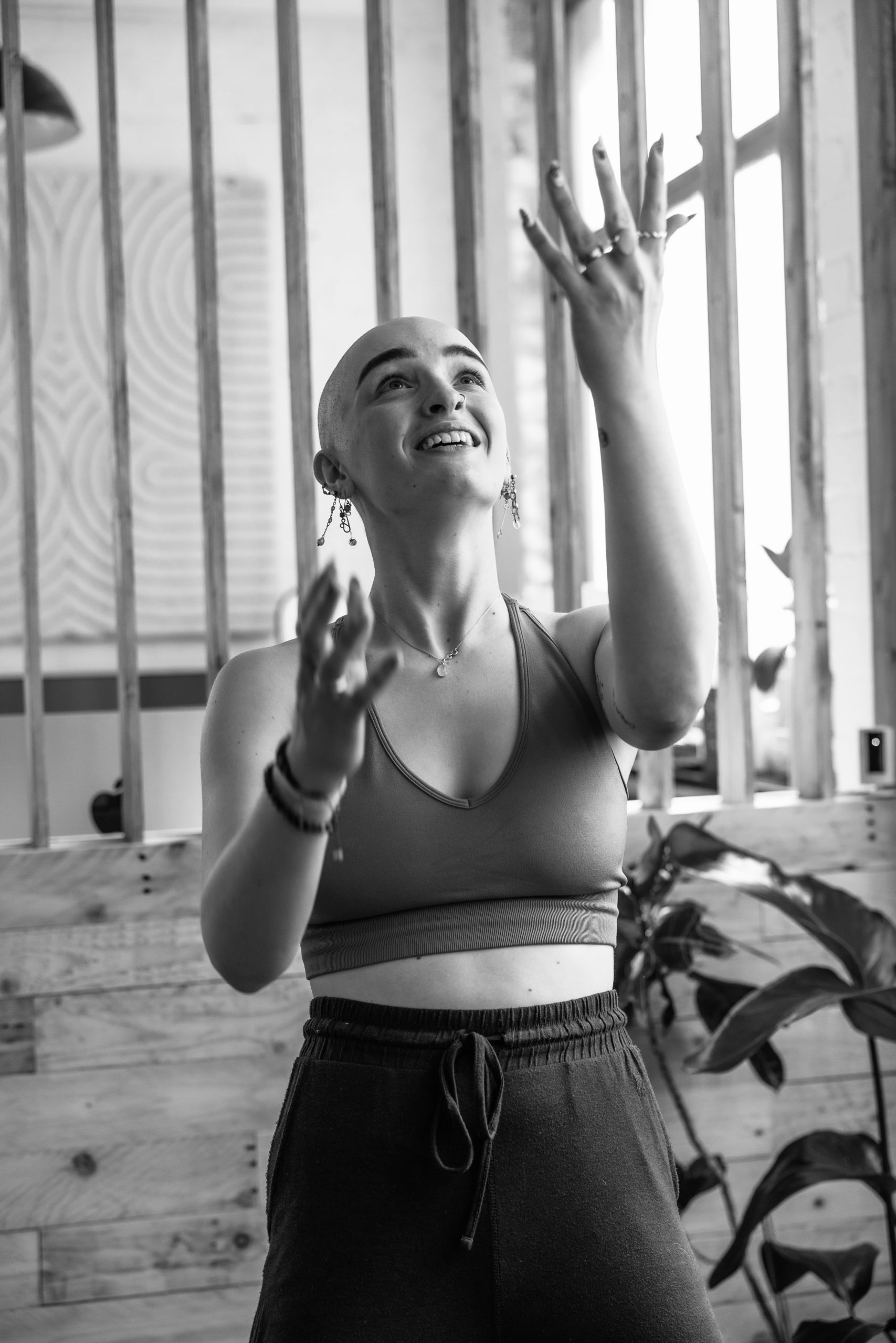 Person practicing slow, intentional movement in a bright studio space — somatic yoga for nervous system regulation and embodied awareness. Play. Fun. Curiosity.