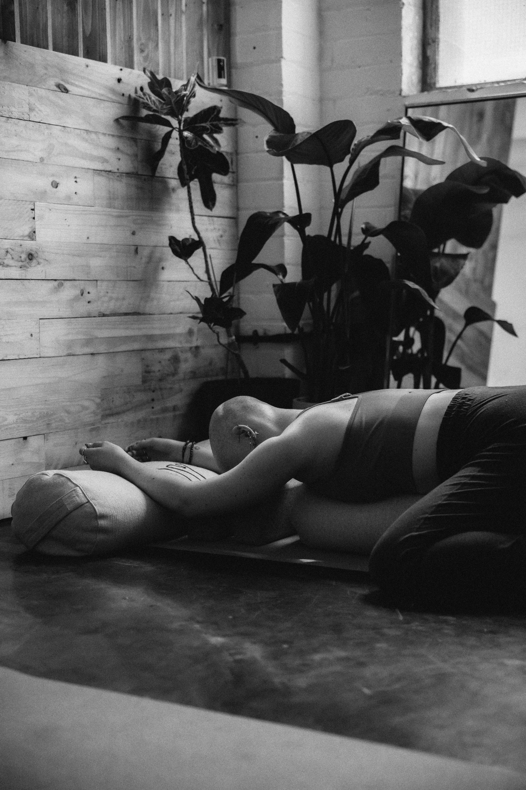 Person practicing slow, intentional movement in a bright studio space — somatic yoga for nervous system regulation and embodied awareness.