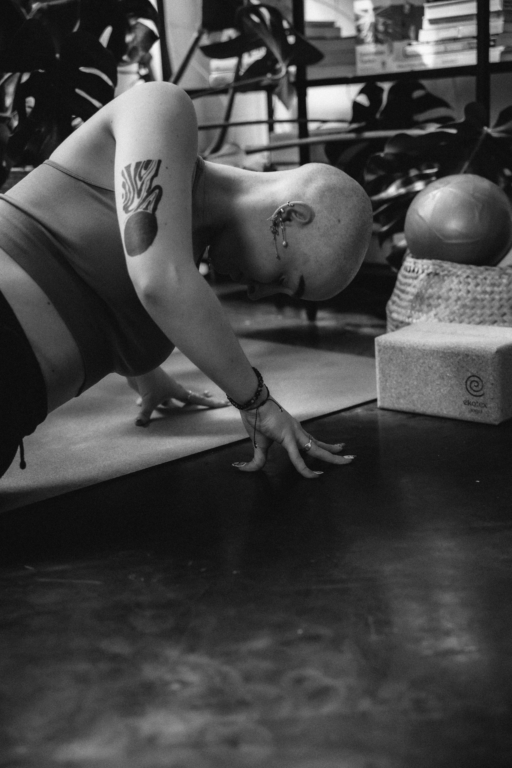 Person practicing slow, intentional movement in a bright studio space — somatic yoga for nervous system regulation and embodied awareness.