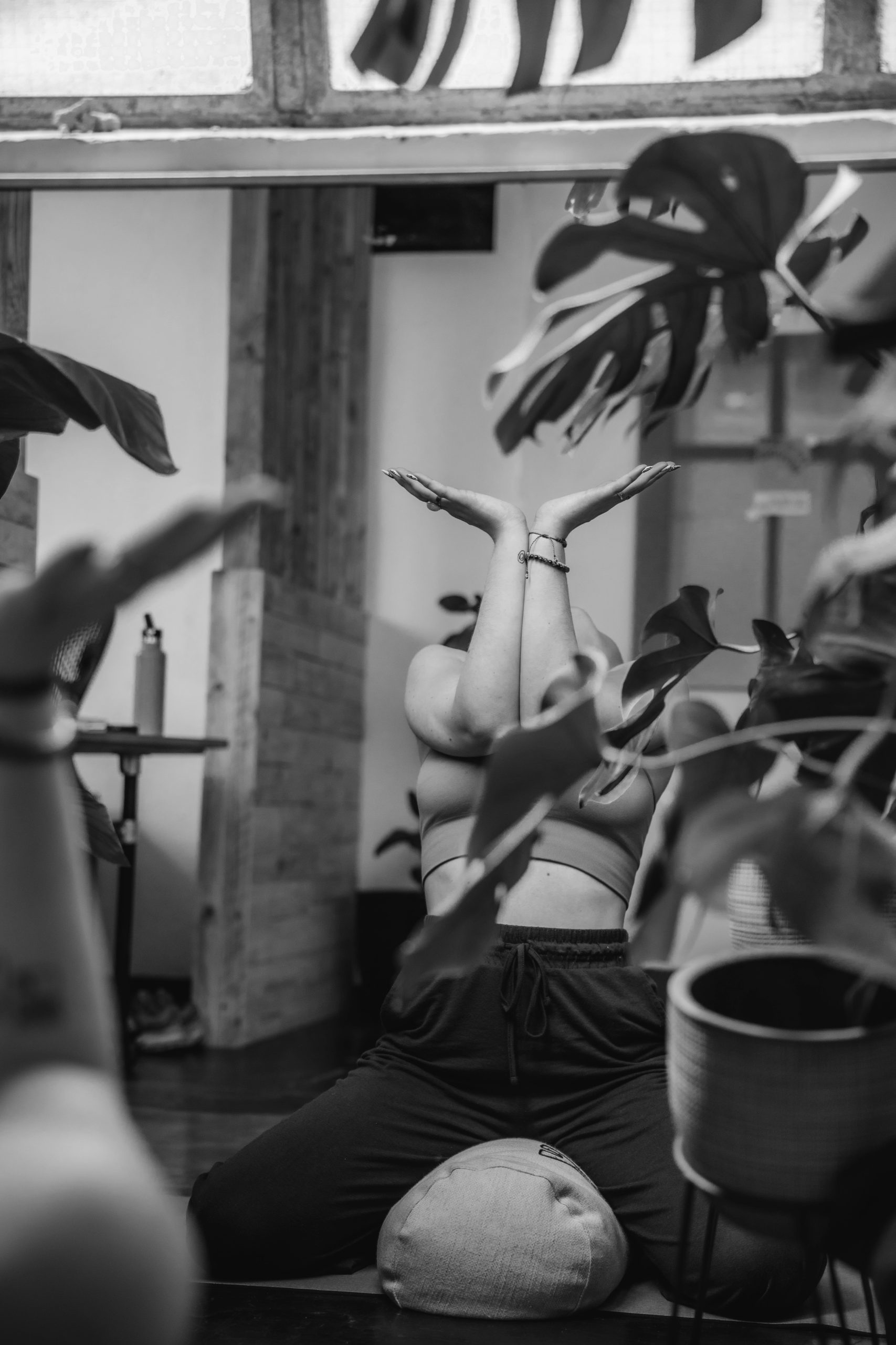 Person practicing slow, intentional movement in a bright studio space — somatic yoga for nervous system regulation and embodied awareness.
